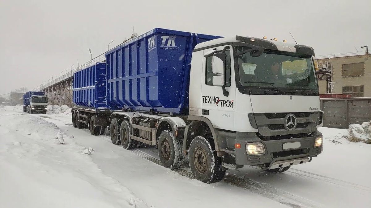 Грузовики «Техно-Строй» с бункерами на заснеженной дороге